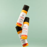 Three The Body Shop Vitamin C Skin Boost Instant Smoother 30 ML bottles displayed against a soft green background