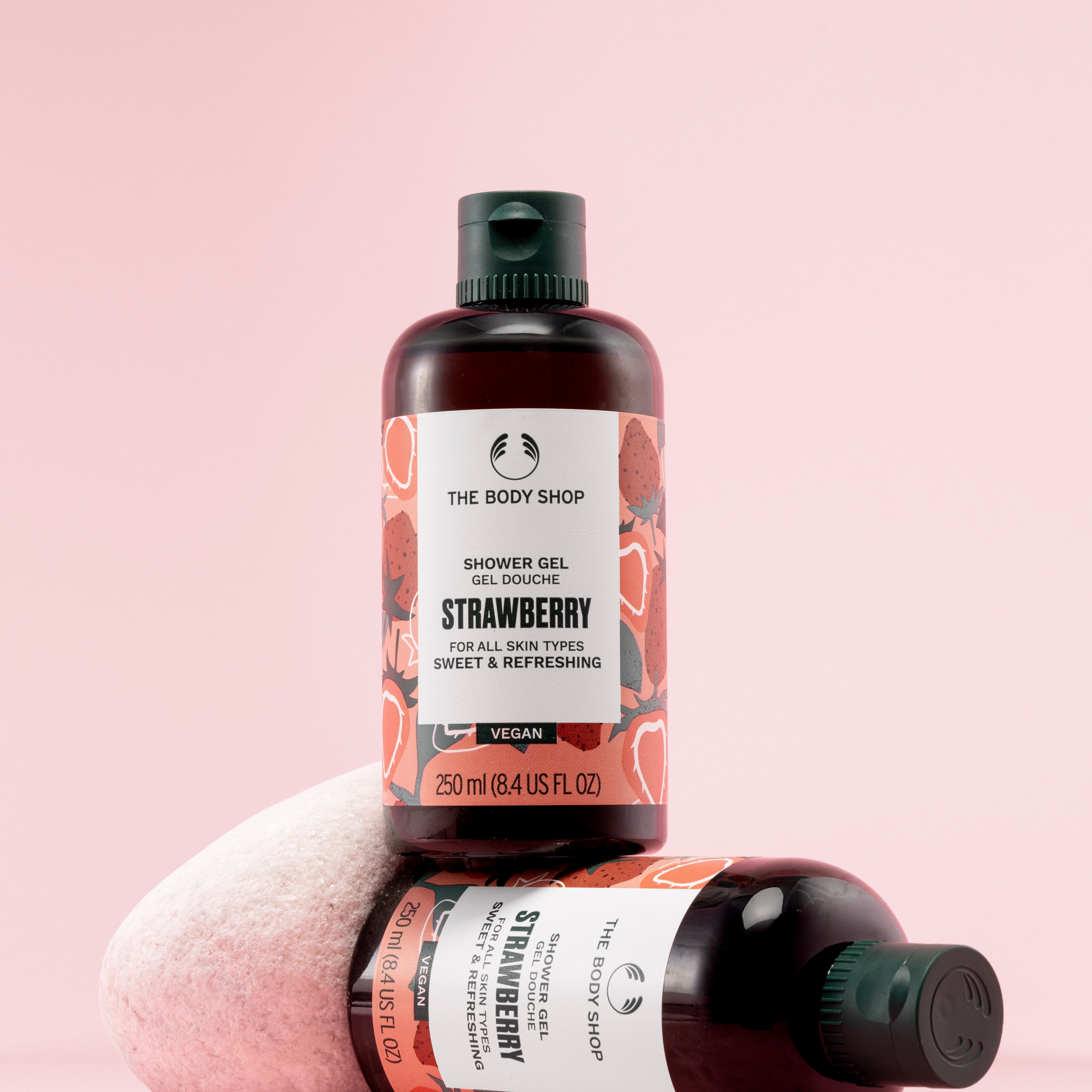 The Body Shop Strawberry Shower Gel 250 ML against soft pink background, highlighting vibrant labels.