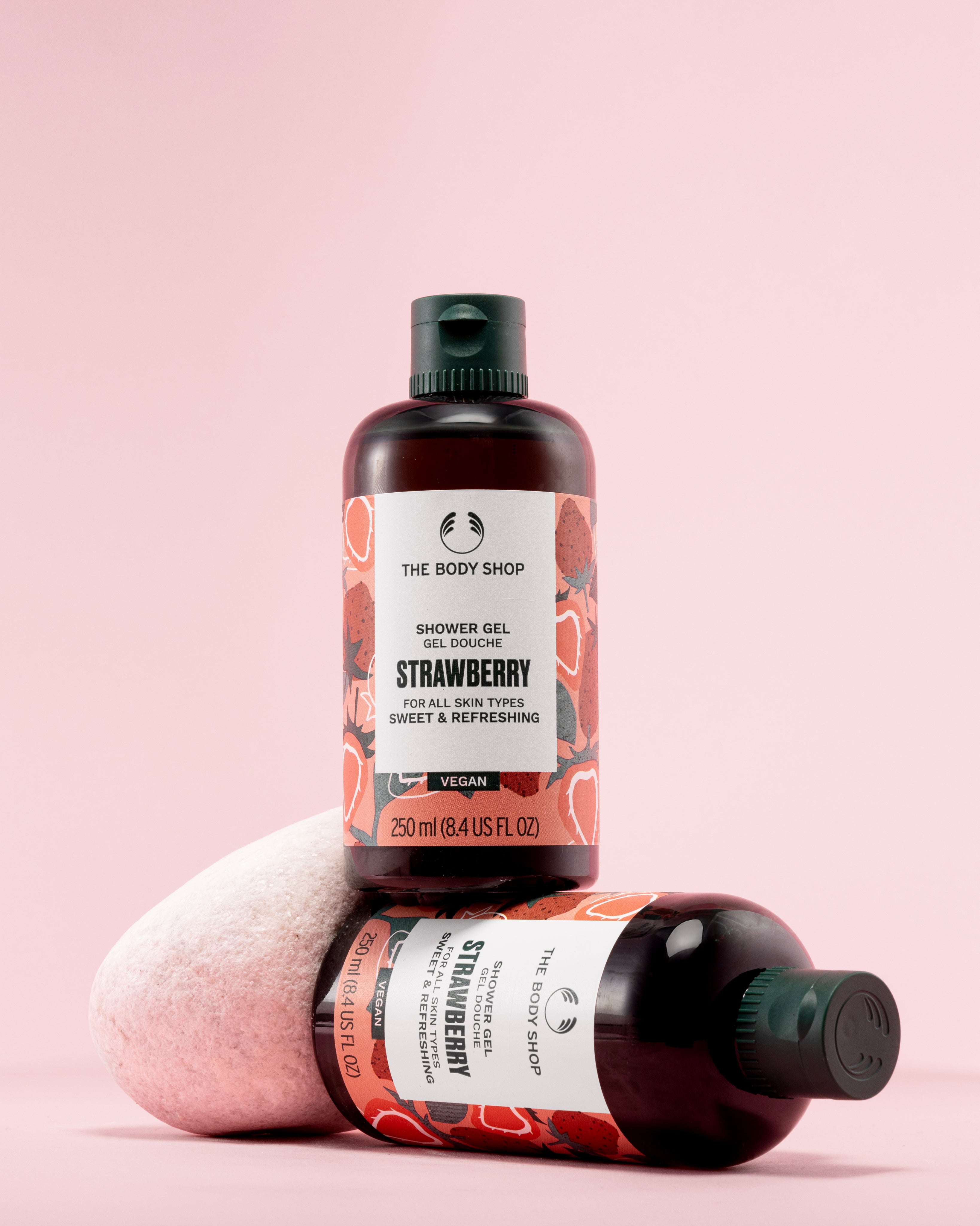 The Body Shop Strawberry Shower Gel 250 ML against soft pink background, highlighting vibrant labels.