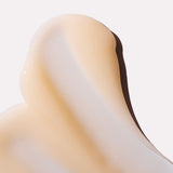Close-up view of a creamy product displaying a smooth, blended texture on a neutral background.