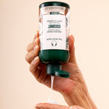 Hand dispensing The Body Shop Coconut Shower Cream 250 ML into palm, in relaxing bathroom setting