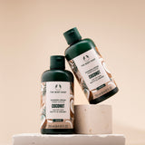 Two bottles of The Body Shop Coconut Shower Cream 250ml displayed on light backdrop, emphasizing design.