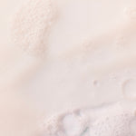 Creamy Coconut Shower Cream 250 ML against a soft light background, showcasing bubbles and a smooth texture.