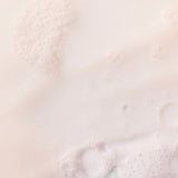 Creamy Coconut Shower Cream 250 ML against a soft light background, showcasing bubbles and a smooth texture.