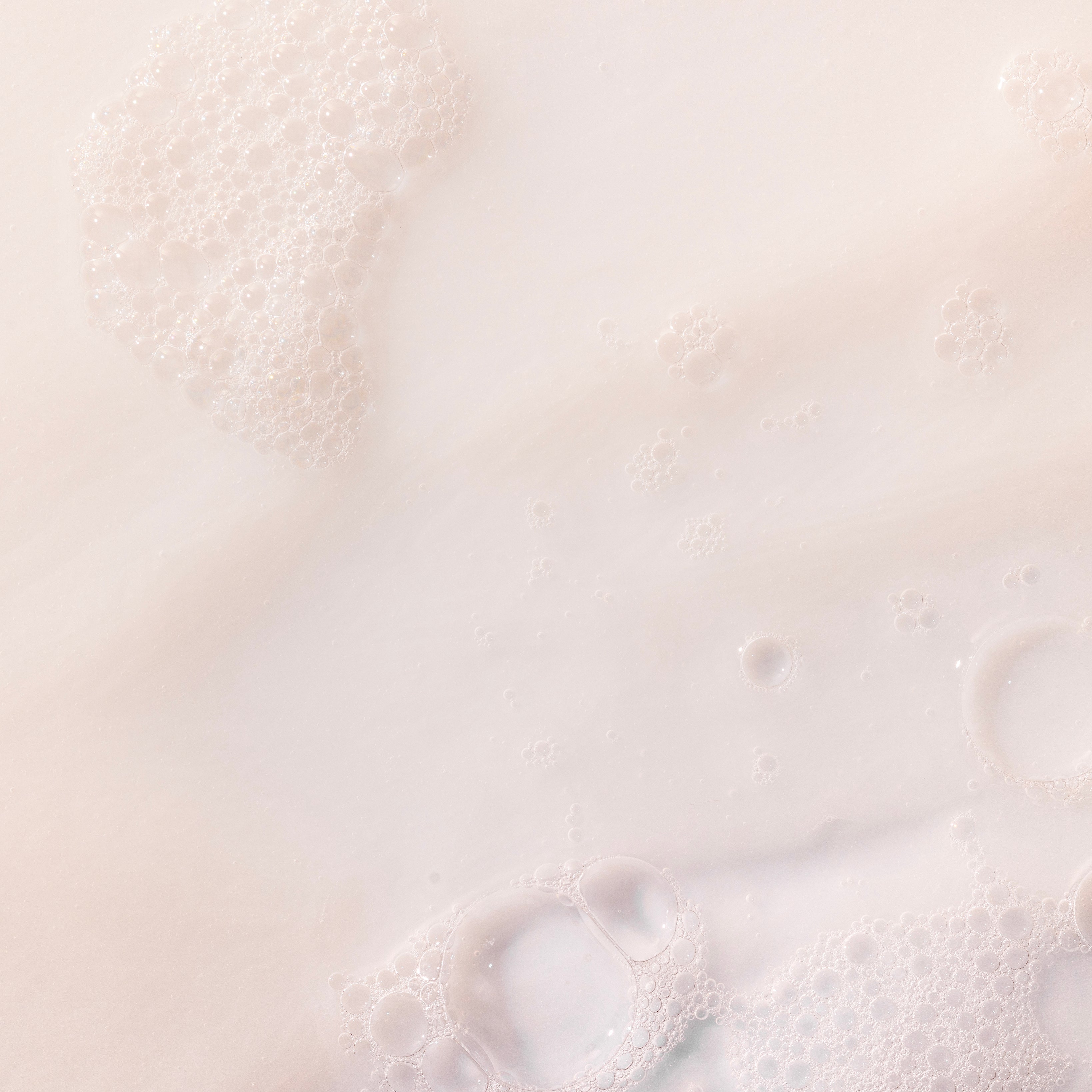 Creamy Coconut Shower Cream 250 ML against a soft light background, showcasing bubbles and a smooth texture.