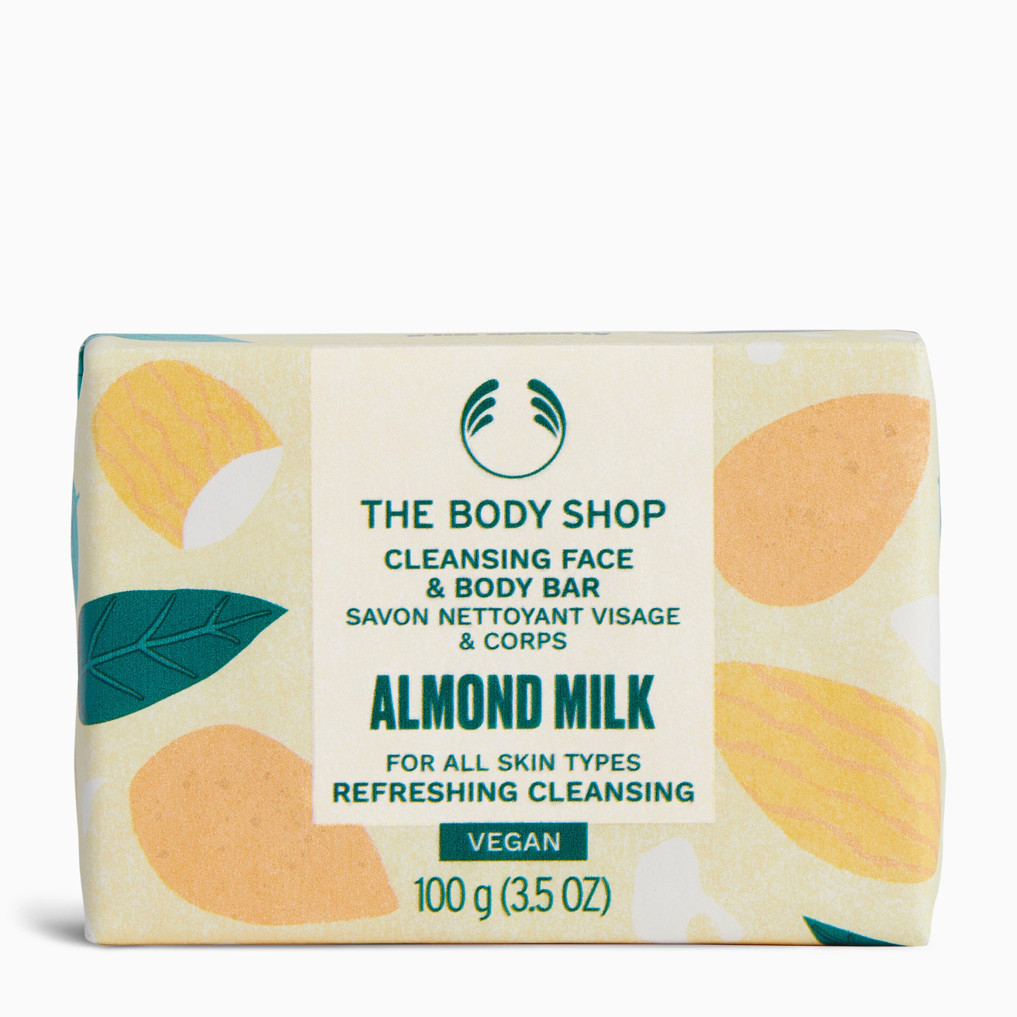Close-up of The Body Shop Cleansing Face & Body Bar Almond Milk 100G on colorful packaging against white background