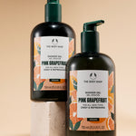 Two bottles of The Body Shop Pink Grapefruit Shower Gel 750 ML against a soft beige background.