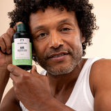 Man holding The Body Shop Aloe Soothing Toner 250 ML in light-colored studio setting