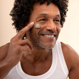 Man applying a charcoal pore minimizing mask 75ml on clean backdrop during skincare routine