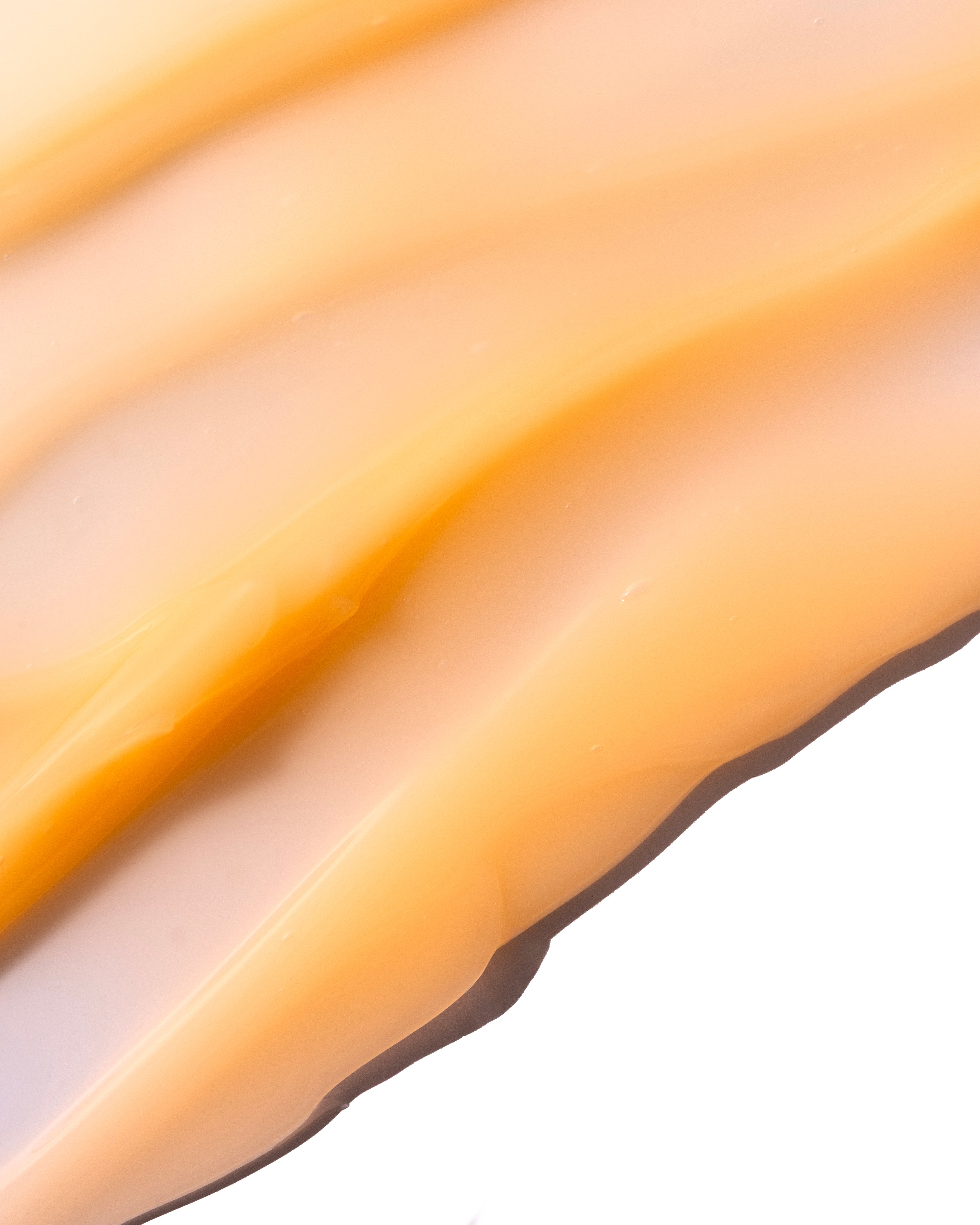 Close-up of a smooth, golden Vitamin C Glow Boosting Intense Moisturiser 50ml showcasing its creamy texture