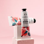 Stylish display of The Body Shop British Rose Hand Cream 30 ML on geometric blocks against a soft pink background