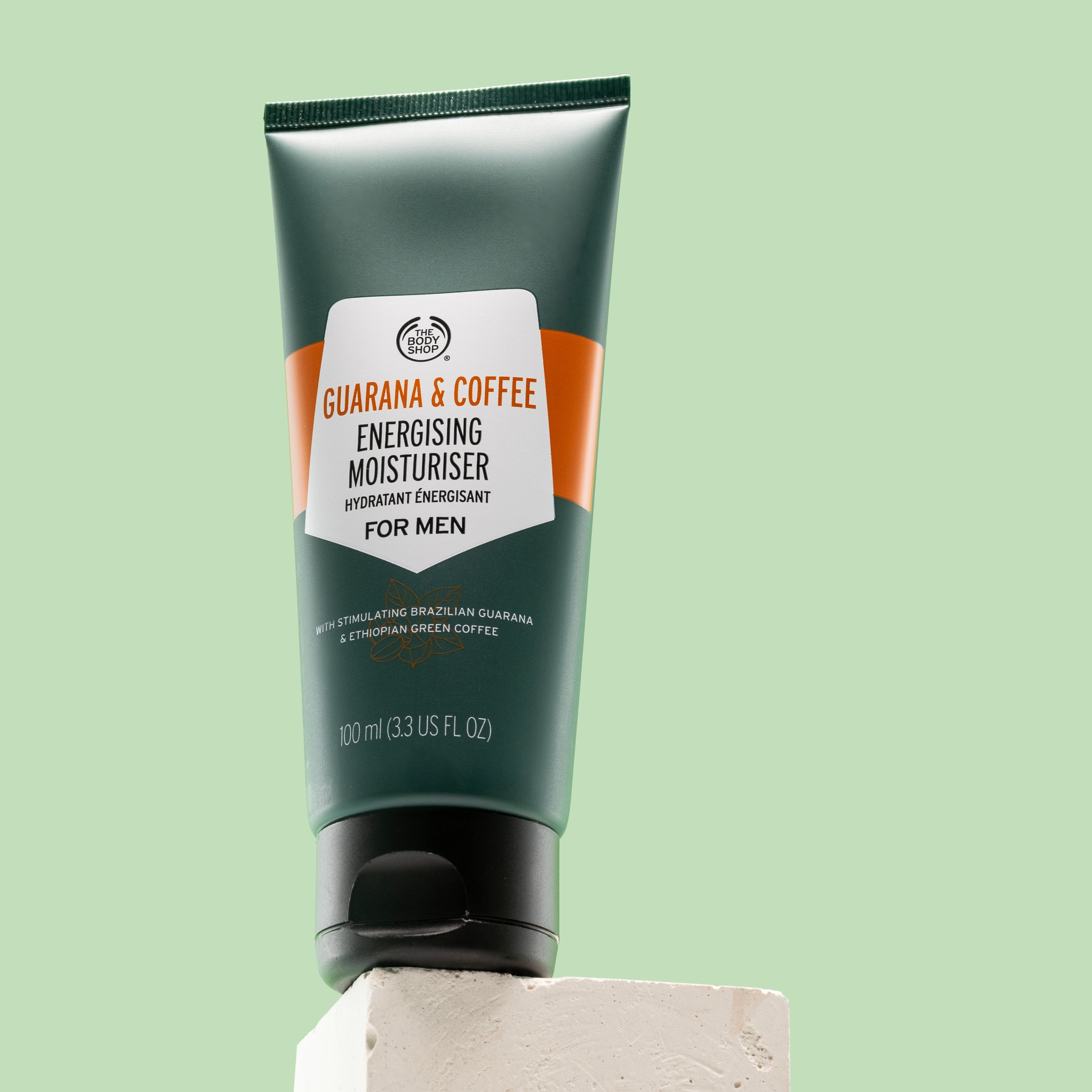 Guarana & Coffee Energising Moisturiser For Men 100 ML on white block against green background
