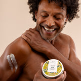 Man showcasing The Body Shop Olive Body Butter 200 ML, displaying creamy texture on his arm.