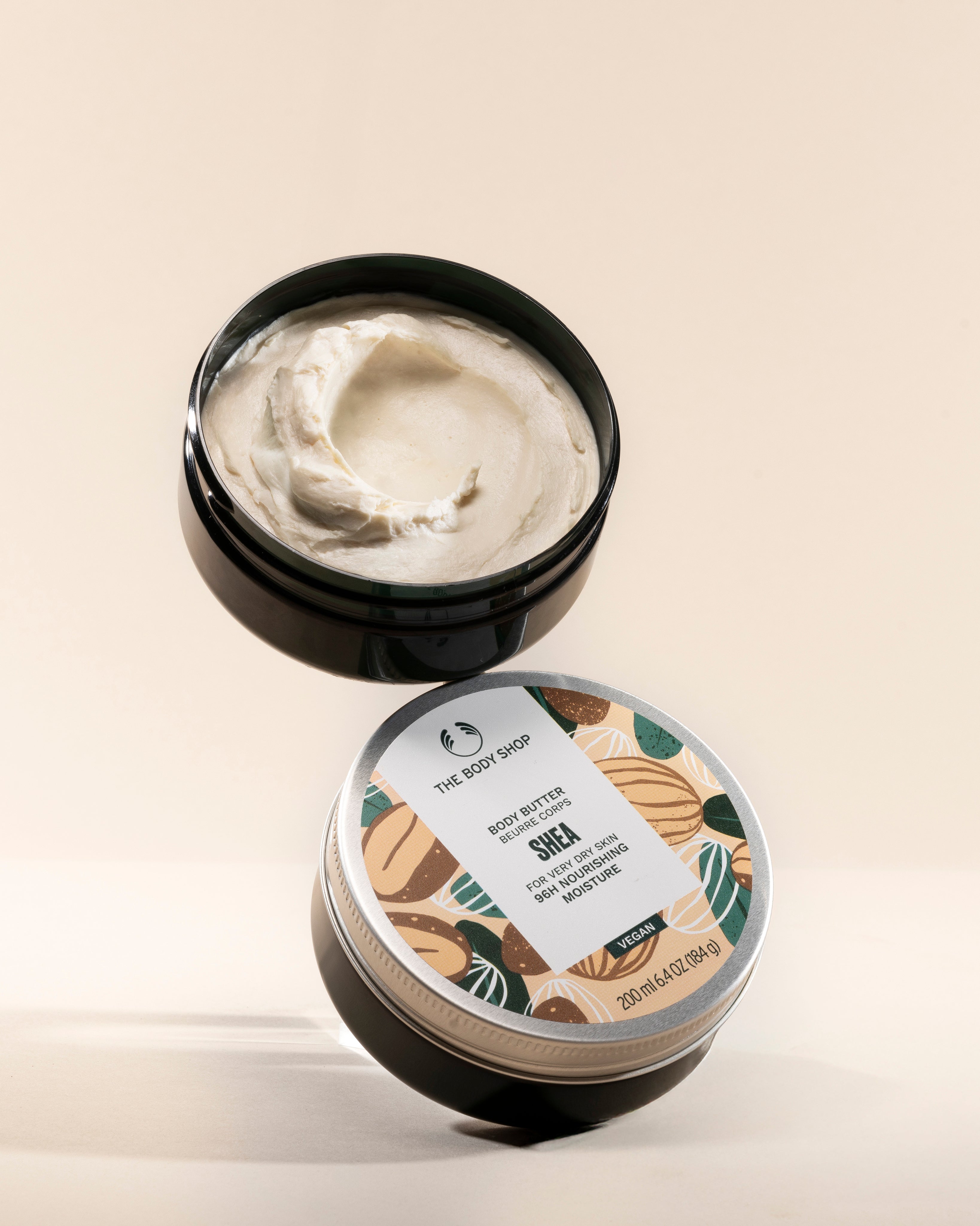 The Body Shop Shea Body Butter 200 ML against a clean minimal backdrop, highlighting creamy texture and vibrant packaging.