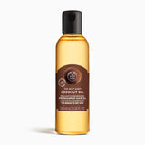 Bottle of The Body Shop Coconut Oil 200ml against white background for nourishing hair before shampooing.