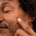 Man applying The Body Shop Maca Root & Aloe Post Shave Water Gel 160 ML on his cheek after shaving.