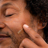 Man applying The Body Shop Maca Root & Aloe Post Shave Water Gel 160 ML on his cheek after shaving.