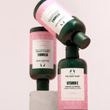 Visually appealing display of The Body Shop Vitamin E Cream Cleanser 250 ML on light backdrop with stone display.