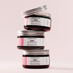 Three jars of The Body Shop Vitamin E Moisture Day Cream stacked on a light pink background