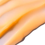 Close-up of a smooth, golden Vitamin C Glow Boosting Intense Moisturiser 50ml showcasing its creamy texture