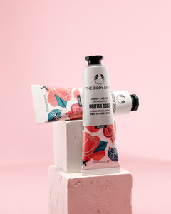 Stylish display of The Body Shop British Rose Hand Cream 30 ML on geometric blocks against a soft pink background