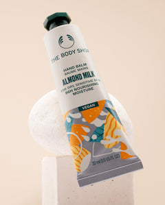 The Body Shop Almond Milk Hand Balm 30 ML on a stylish studio backdrop, showcasing nourishing properties.
