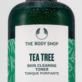 Close-up of The Body Shop Tea Tree Skin Clearing Toner, droplets on bottle against clean backdrop.