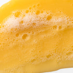 Close-up of Banana Truly Nourishing Shampoo 250 ML highlighting rich texture on white background.