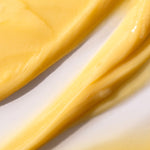 Close-up of Banana Truly Nourishing Conditioner 250 ML, showcasing its creamy yellow texture against a light background.