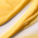Close-up of Banana Truly Nourishing Conditioner 250 ML, showcasing its creamy yellow texture against a light background.