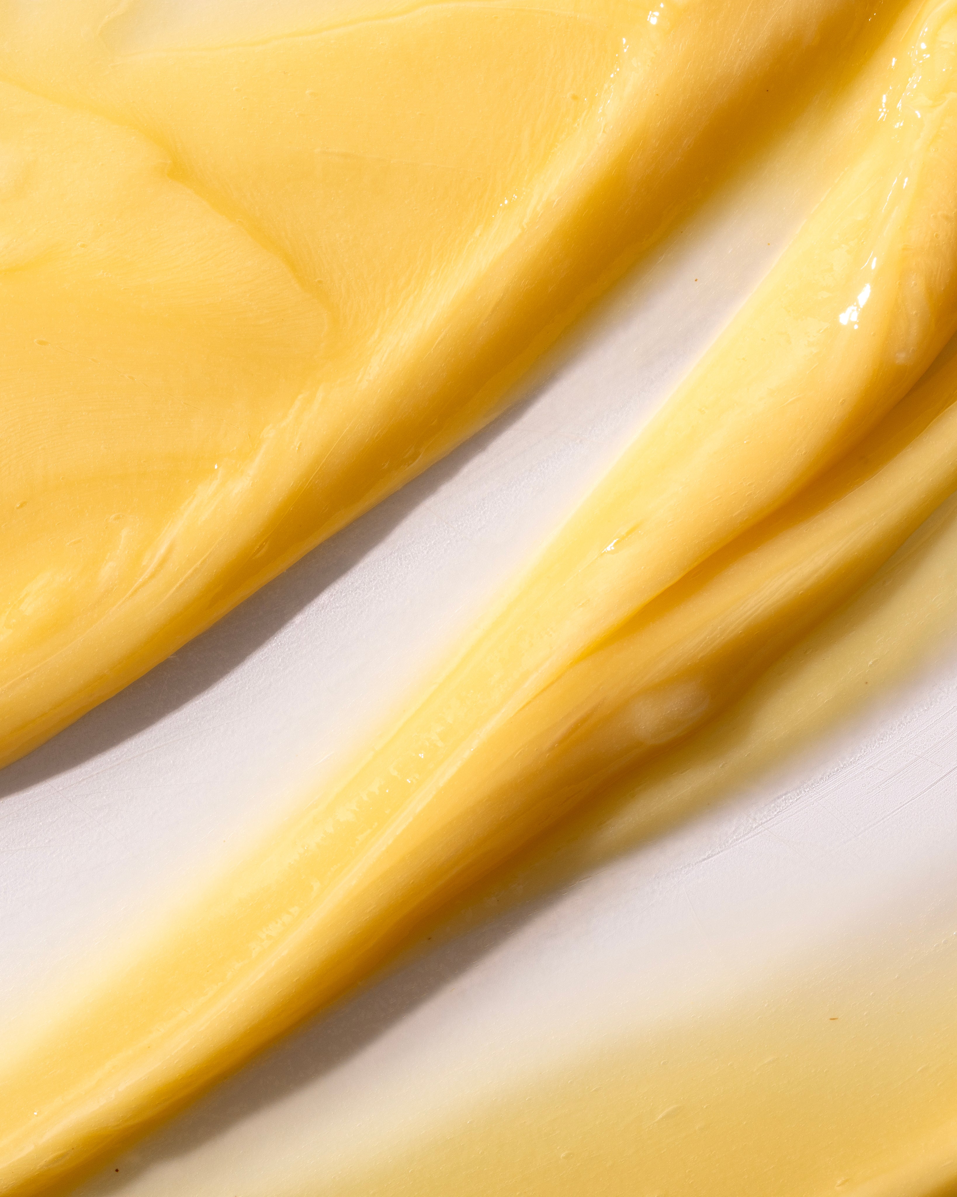 Close-up of Banana Truly Nourishing Conditioner 250 ML, showcasing its creamy yellow texture against a light background.