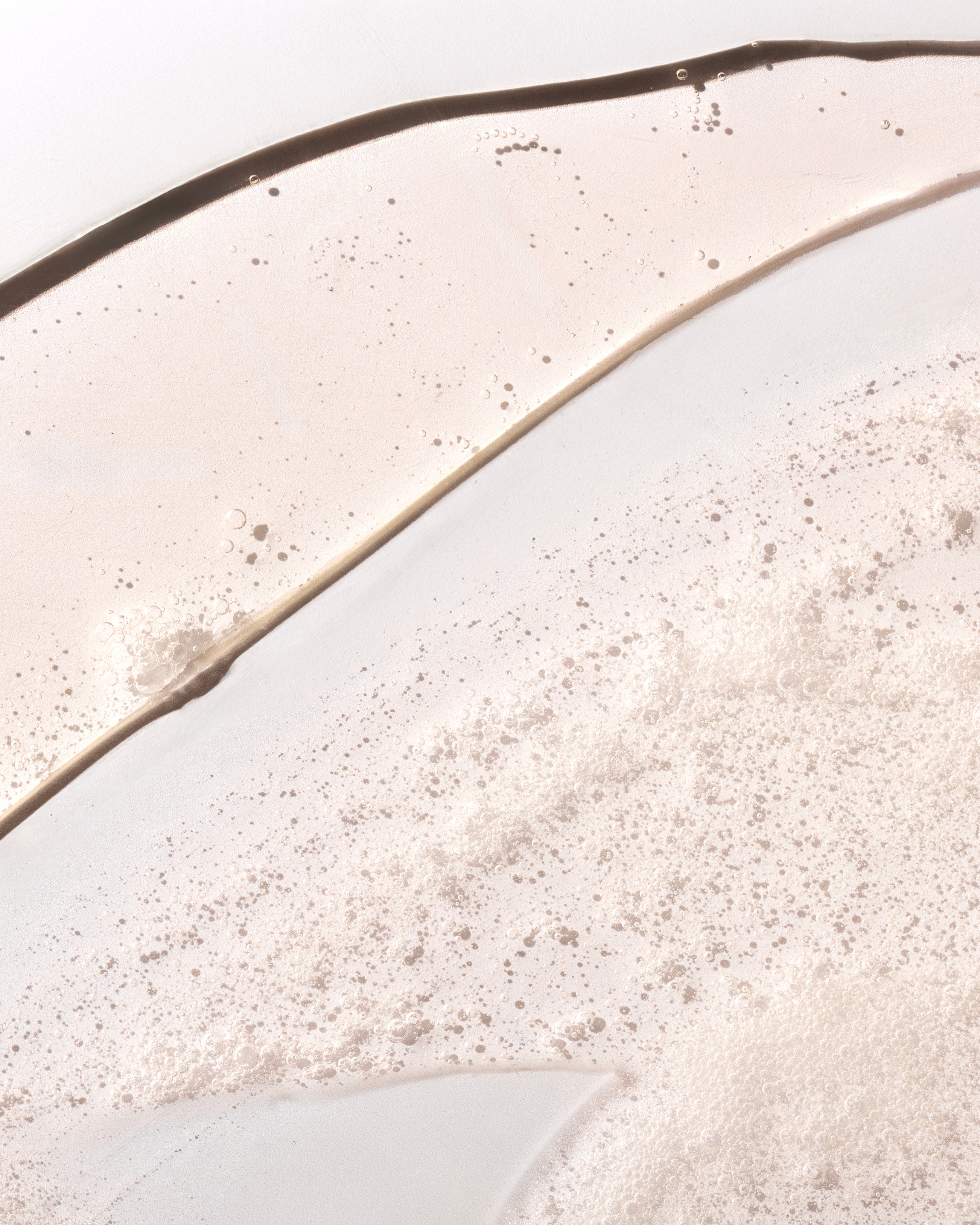 Close-up of ginger scalp care shampoo 250ml displaying bubbly texture against a clean background.