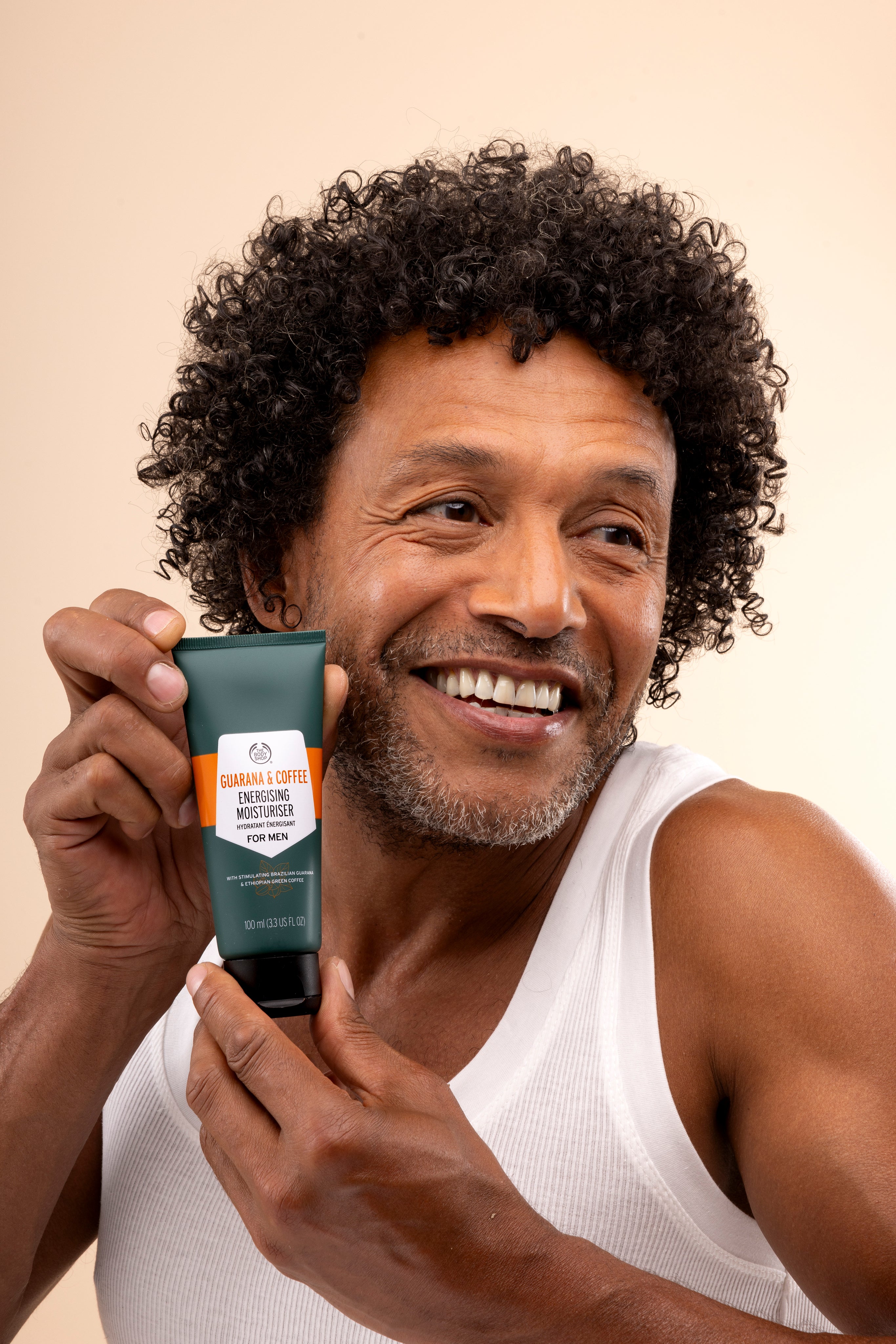 Man displaying Guarana & Coffee Energising Moisturiser For Men 100 ML against neutral background