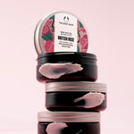 A stack of The Body Shop British Rose Body Butter 200ml against a soft pink backdrop.