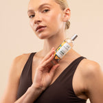 Model showcasing The Body Shop Satsuma Body Mist 100ml against soft, neutral background