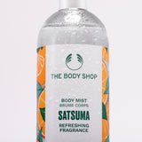 Close-up of The Body Shop Satsuma Body Mist 100ml bottle with vibrant label and condensation