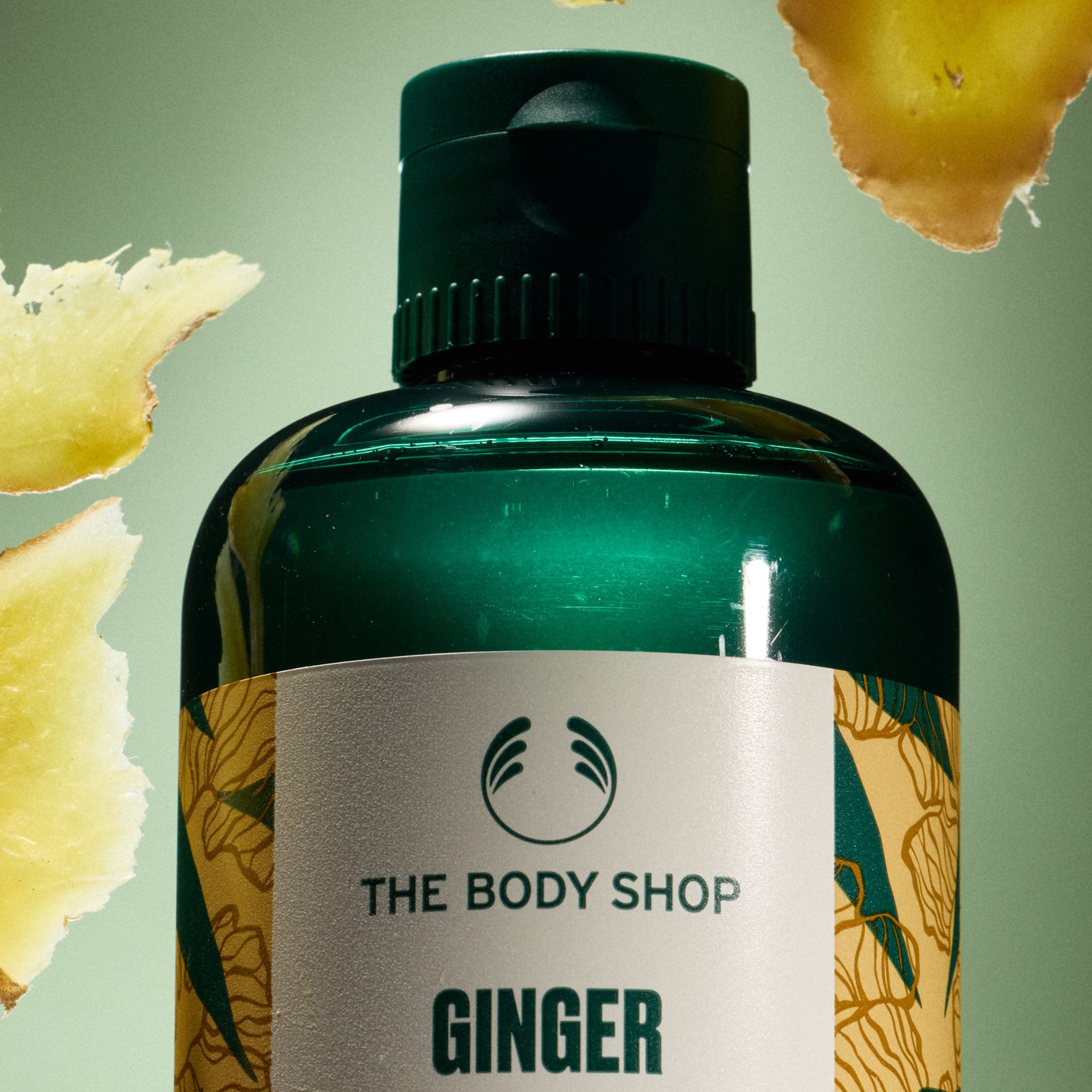 The Body Shop Ginger product with ginger slices on a green background